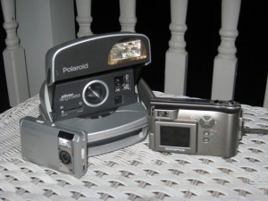 picture at night of various cameras on a wicker table polaroid